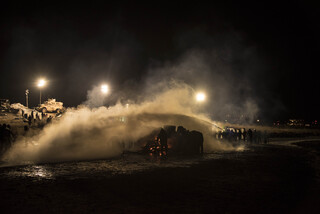 Water protectors ignite fires for warmth for hypothermic victims of water cannons and as a symbol of sacred fire and tradition. They use blue tarps to protect the fires from the law enforcement water hoses.